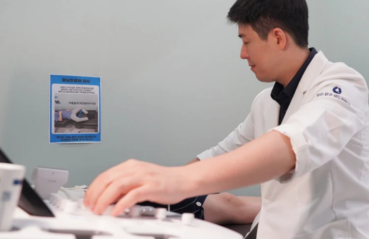 비뇨의학과 전문의가 환자에게 초음파 검사를 시행하며 질환을 진단하는 모습